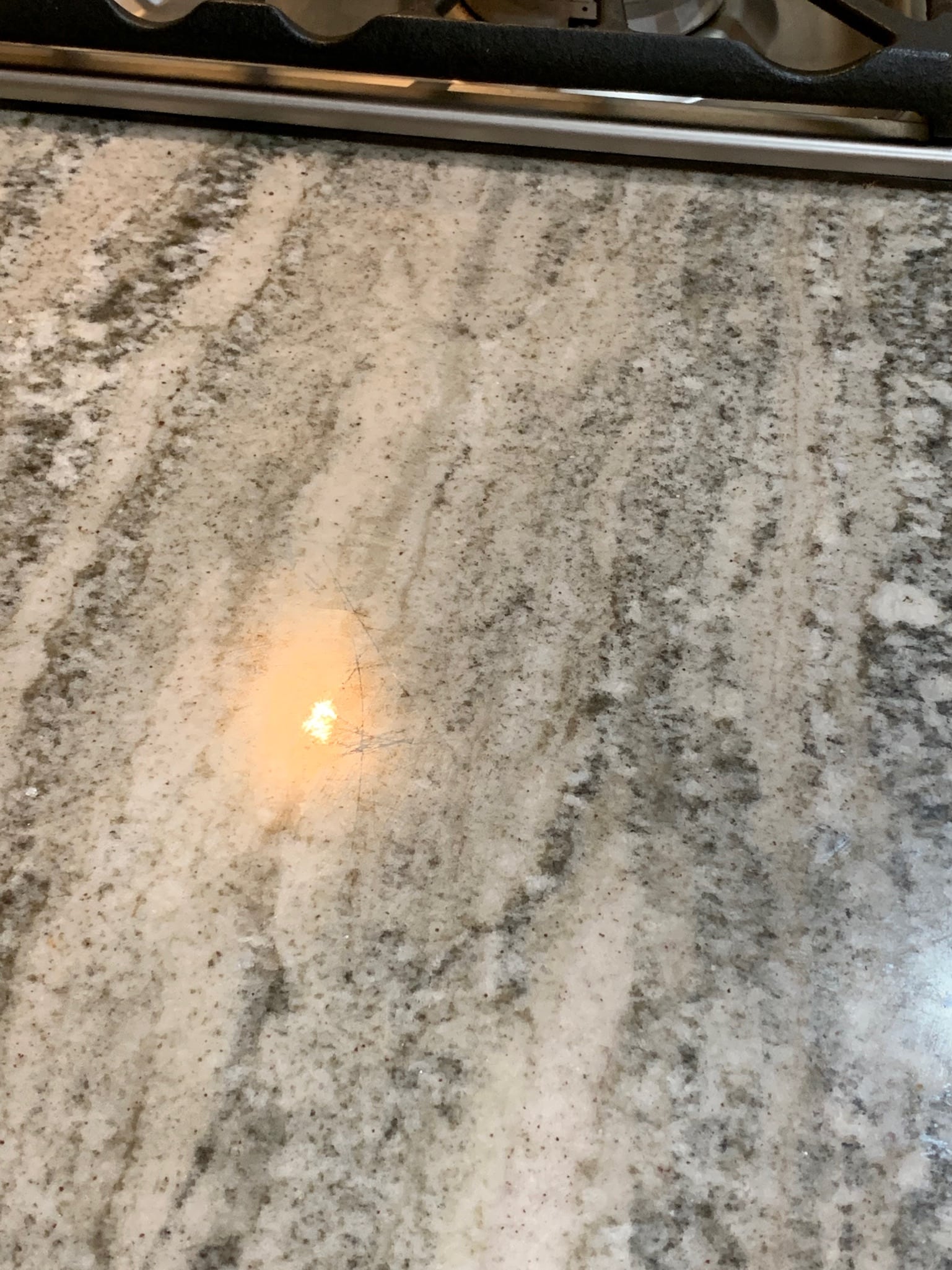 Granite countertop with cloudy sealer residue before restoration in Montgomery, TX